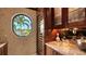 Sophisticated bar area with custom cabinets and a wine cooler, offering a peek at tropical views at 279 Robin Dr, Sarasota, FL 34236