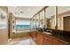 Luxurious bathroom with dual sinks, granite counters, a soaking tub, and marina views at 279 Robin Dr, Sarasota, FL 34236