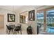 Dining area with modern glass table, sleek black chairs, and views of the pool and marina at 279 Robin Dr, Sarasota, FL 34236