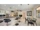 Modern kitchen with stainless steel appliances, black countertops, bar seating, and a dining area at 279 Robin Dr, Sarasota, FL 34236