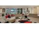 Bright living room with large windows overlooking the waterfront, neutral decor, and adjacent staircase at 279 Robin Dr, Sarasota, FL 34236