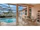Covered patio boasts tile floors, outdoor dining, and serene pool and harbor views at 279 Robin Dr, Sarasota, FL 34236