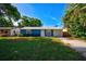 Newly renovated blue house with a metal roof, driveway, and grassy yard at 3110 Elmer St, Sarasota, FL 34231