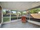 Relaxing screened porch with tile flooring and wicker chair, overlooking backyard at 3110 Elmer St, Sarasota, FL 34231