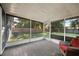 Relaxing screened porch with tile flooring and wicker chair, overlooking backyard at 3110 Elmer St, Sarasota, FL 34231