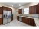 A well-lit kitchen with stainless steel appliances, granite countertops and wood cabinets at 3310 Twin Rivers Trl, Parrish, FL 34219