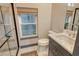 Bathroom featuring a tiled shower with a window, a modern sink and a toilet at 3580 Fair Oaks Ln, Longboat Key, FL 34228