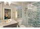 Modern bathroom with a glass shower featuring marble-style tiling, quartz vanity countertop, and a large mirror at 3580 Fair Oaks Ln, Longboat Key, FL 34228