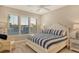 Bright bedroom featuring a ceiling fan, large windows with shutters, and nautical-themed bedding and furnishings at 3580 Fair Oaks Ln, Longboat Key, FL 34228