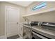 Updated laundry room with front loading washer and dryer, sink, and white shelving at 3580 Fair Oaks Ln, Longboat Key, FL 34228