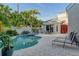 An in-ground pool surrounded by lush landscaping, patio furniture and outdoor seating, perfect for relaxation at 3580 Fair Oaks Ln, Longboat Key, FL 34228