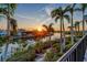 Sunset view of a waterfront home with palm trees and a private dock at 3580 Fair Oaks Ln, Longboat Key, FL 34228