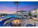 Expansive patio with firepit, pool, and seating area at sunset at 3611 99Th W St, Bradenton, FL 34210