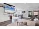 Spacious living room with a retractable TV, comfy seating, and hardwood floors at 3611 99Th W St, Bradenton, FL 34210