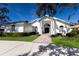 Front view of a white house with a portico and landscaped yard at 3649 Wilderness W Blvd, Parrish, FL 34219