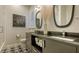 Modern bathroom featuring double sinks, stylish mirrors, black and white tile, and glass-enclosed shower at 400 N Washington Dr, Sarasota, FL 34236