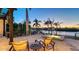 Inviting patio with comfortable seating, hot tub, and a picturesque view of the calm, serene waterfront and lush palm trees at 400 N Washington Dr, Sarasota, FL 34236