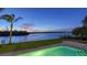Backyard pool with views of the water at dusk, surrounded by well-maintained landscaping and a spacious patio at 400 N Washington Dr, Sarasota, FL 34236