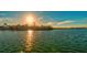 Stunning waterfront home overlooking calm waters, bathed in golden sunlight under a clear, blue sky at sunset at 400 N Washington Dr, Sarasota, FL 34236