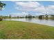 Serene lakefront view with lush green grass and mature trees at 4001 Crockers Lake Blvd # 11, Sarasota, FL 34238