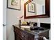 Bathroom with dark vanity, granite countertop, and framed mirror at 4010 18Th W Ave, Bradenton, FL 34205