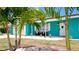 Teal house with palm trees, white door, and seating area on the porch at 4010 18Th W Ave, Bradenton, FL 34205