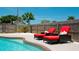 Two red chaise lounges next to a refreshing kidney-shaped pool at 4010 18Th W Ave, Bradenton, FL 34205