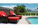 Relaxing poolside loungers with red cushions and side table at 4010 18Th W Ave, Bradenton, FL 34205