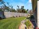 Landscaped backyard with grassy area and wooden fence at 4153 Lenox Blvd, Venice, FL 34293