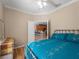 Bedroom with teal bedding, ceiling fan and view into kitchen at 4153 Lenox Blvd, Venice, FL 34293