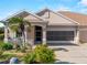 Tan house with a two-car garage and nicely landscaped yard at 4153 Lenox Blvd, Venice, FL 34293