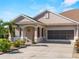 Tan house with a two-car garage and nicely landscaped yard at 4153 Lenox Blvd, Venice, FL 34293