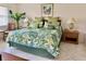 King-size bed, tropical bedding, nightstands, and a sitting area with chairs and a small table at 4515 45Th W Ave # 201A, Bradenton, FL 34210