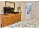 Bedroom with dresser, TV, and view into adjacent living area at 4515 45Th W Ave # 201A, Bradenton, FL 34210