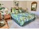 King-size bed with tropical bedding, nightstands, and a mirror at 4515 45Th W Ave # 201A, Bradenton, FL 34210