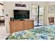 Bedroom with large dresser, TV, and access to a private balcony at 4515 45Th W Ave # 201A, Bradenton, FL 34210