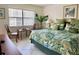 King-size bed with tropical comforter, sitting area, and view from window at 4515 45Th W Ave # 201A, Bradenton, FL 34210