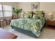 King-size bed with tropical comforter, nightstands with lamps, and a sitting area at 4515 45Th W Ave # 201A, Bradenton, FL 34210