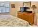 Bedroom with dresser, TV and bedding with coastal theme at 4515 45Th W Ave # 201A, Bradenton, FL 34210