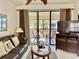 Bright living room with comfy leather sofas, sliding glass doors to balcony, and a large TV at 4515 45Th W Ave # 201A, Bradenton, FL 34210