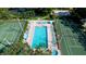 Community pool with surrounding lounge chairs and tennis courts at 4515 45Th W Ave # 201A, Bradenton, FL 34210