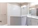 Bright bathroom featuring a double sink vanity with gray cabinetry, a glass-enclosed shower, and stone countertops at 4739 Willow Bend Ave, Parrish, FL 34219