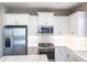 White kitchen featuring stainless steel appliances and fixtures with white subway tile backsplash at 4739 Willow Bend Ave, Parrish, FL 34219