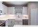 A white kitchen with stainless steel appliances, a farmhouse sink, and a white countertop at 4739 Willow Bend Ave, Parrish, FL 34219
