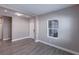 A bright living room with gray wood-look flooring, a window with blinds, and a white door at 4739 Willow Bend Ave, Parrish, FL 34219
