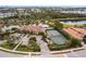 Aerial view of community amenities including clubhouse, pool, tennis court, and pond at 5814 Cavano Dr, Sarasota, FL 34231