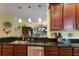 Kitchen featuring stainless steel appliances, dark wood cabinets, granite countertops, and an open view into the living room at 5814 Cavano Dr, Sarasota, FL 34231