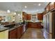 Well-lit kitchen boasts dark wood cabinets, stainless steel appliances, and elegant granite countertops with barstool seating at 5814 Cavano Dr, Sarasota, FL 34231