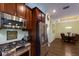 Modern kitchen featuring stainless steel appliances, dark wood cabinets, granite countertops, and adjacent dining room at 5814 Cavano Dr, Sarasota, FL 34231