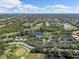 Expansive aerial view of a community featuring golf courses, ponds, and lush green landscaping under a partly cloudy sky at 6211 Skyward Ct, Bradenton, FL 34203